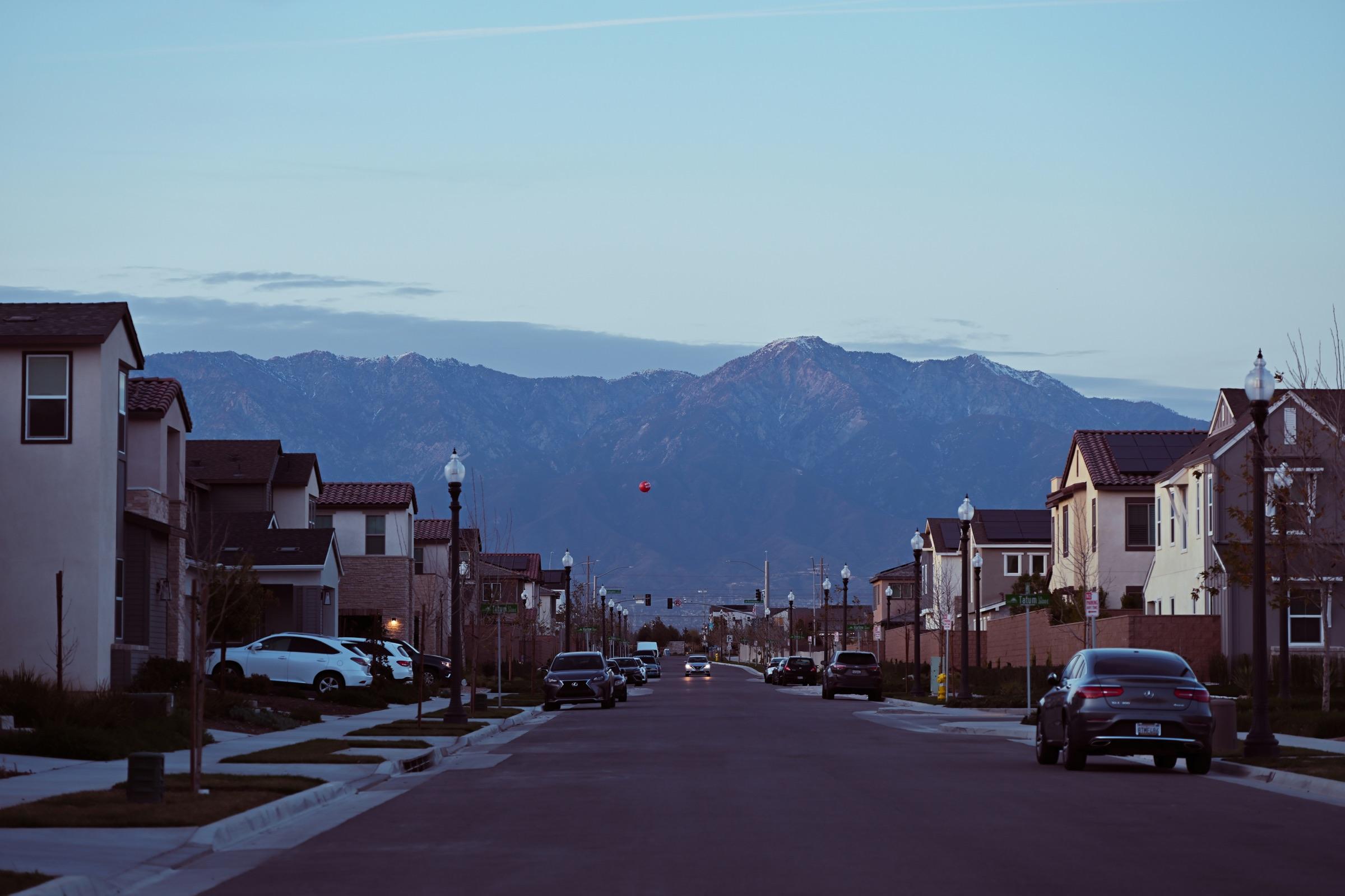 Residential street at dusk with mountains in the background