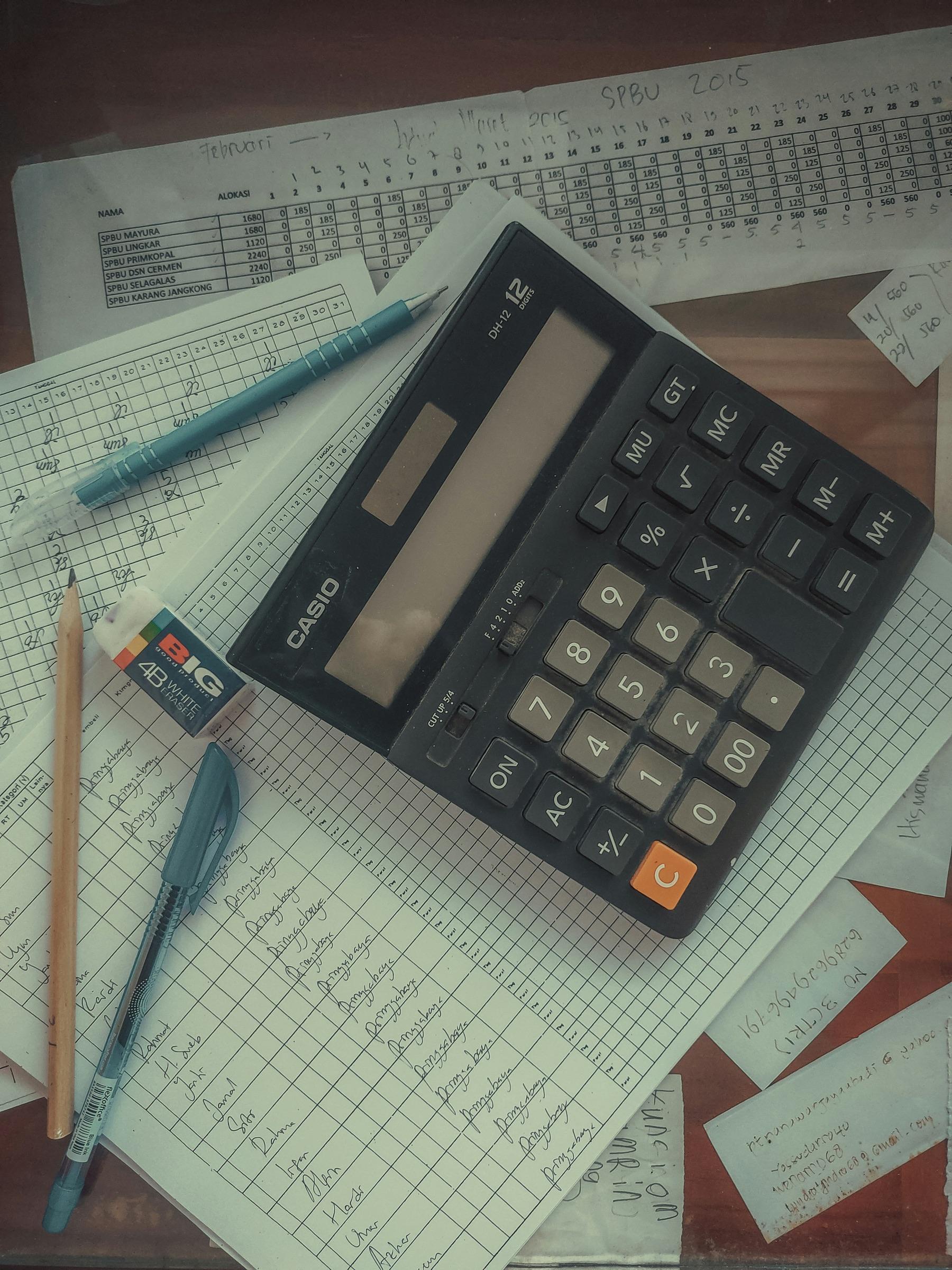Calculator and pen on top of financial paperwork