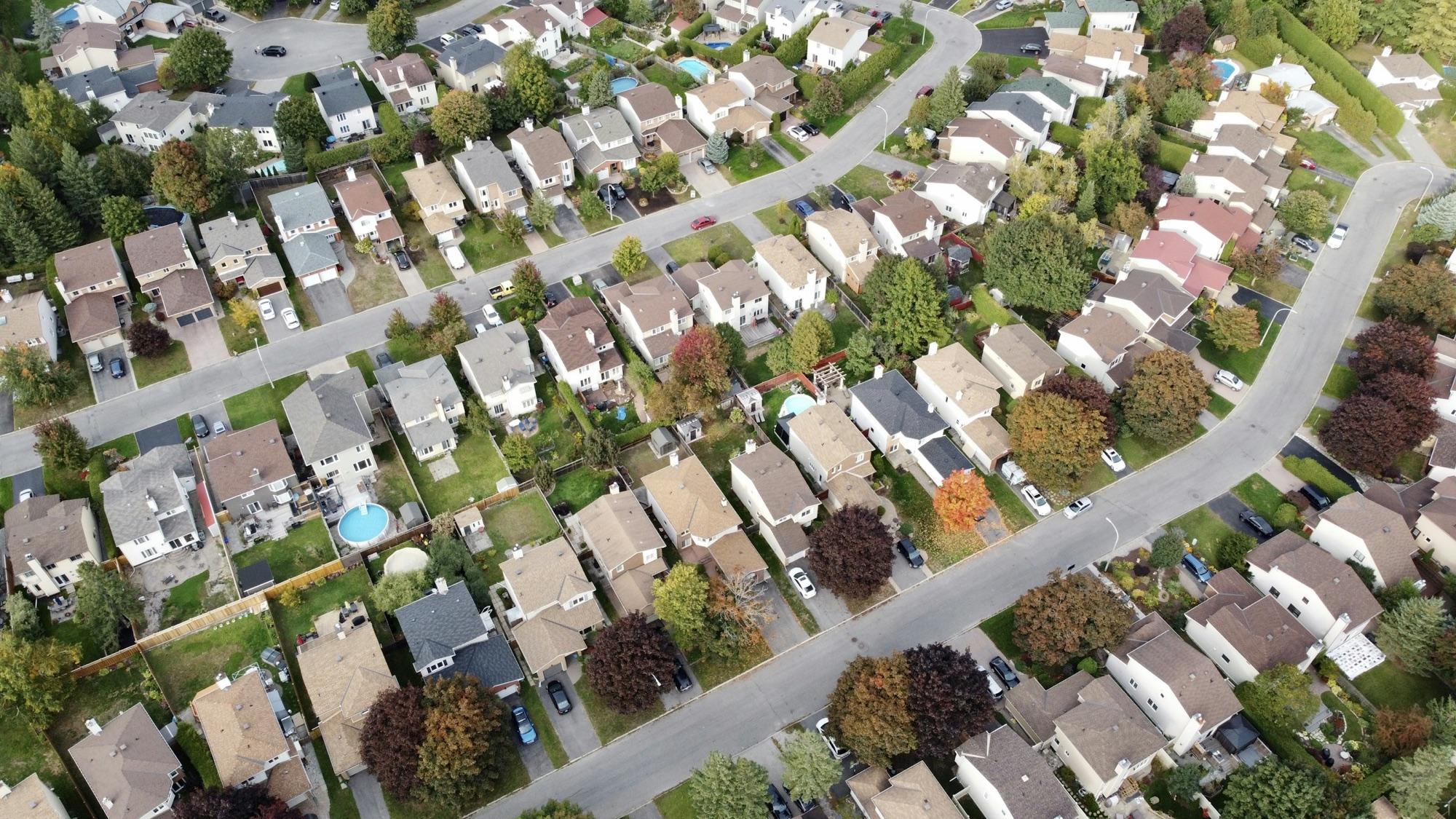 Aerial view of a suburban neighborhood with many distinct homes along tree-lined streets